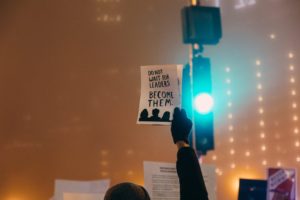 Man holding sign that says "Don't wait for leaders. Become them."